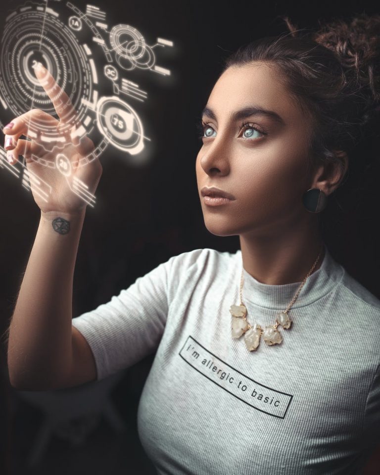 Mujer tocando una interfaz holográfica brillante con la frase "I'm allergic to basic" en su camiseta.