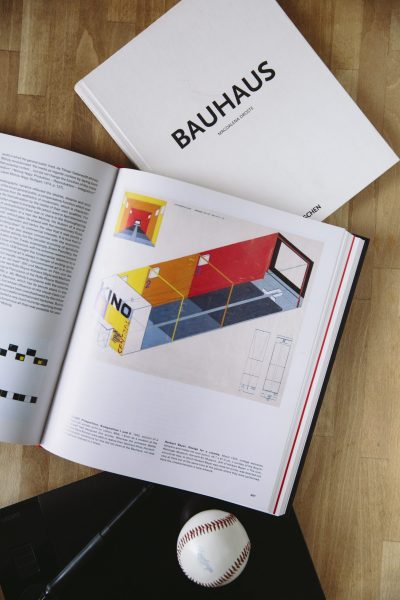 Libro Bauhaus, diseño y arquitectura, Magdalena Droste, ilustración geométrica, pelota de béisbol, superficie de madera.